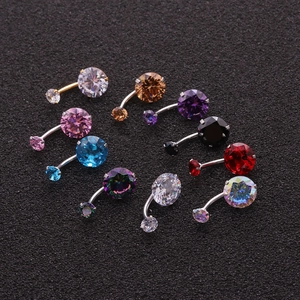Macro display of round zircon belly rings in nine vibrant colors on a black textured background