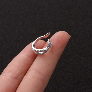 U-shaped silver ear cuff with sparkling cubic zirconia crystals shown on finger