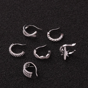 Set of six silver zircon ear cuffs with star and twisted designs on black background