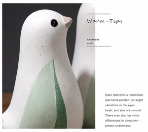 Detailed close-up of a Nordic ceramic bird ornament with hand-painted spots and green wings