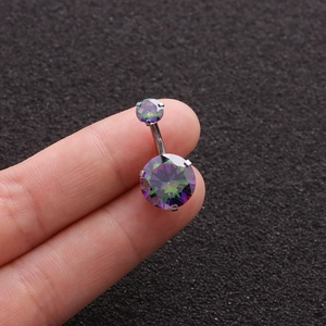 Macro detail of rainbow cubic zirconia belly button ring held between fingers