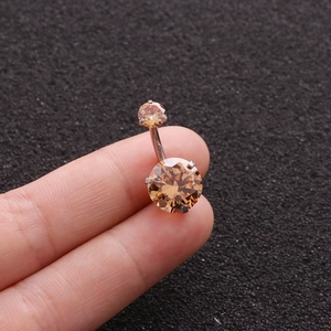Detail of silver belly ring featuring two round amber zircons on a curved barbell