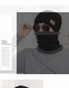 Detailed view of black knitted winter beanie with fleece lining and matching neck warmer