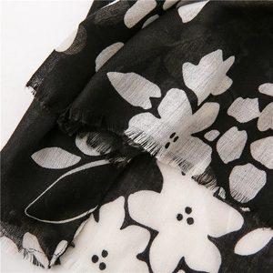 Detailed view of black and white floral cotton linen scarf with soft fringe trim details
