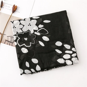 Detail of black and white floral linen scarf featuring delicate frayed fringe edges