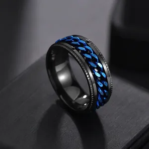 Macro detail of black matte stainless steel ring with blue spinning Cuban chain link