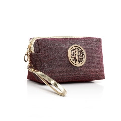 Detail of burgundy glitter makeup bag with gold circular emblem and wrist strap