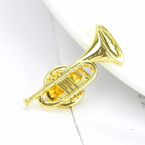 Macro shot of a detailed golden trumpet brooch with polished metallic finish texture
