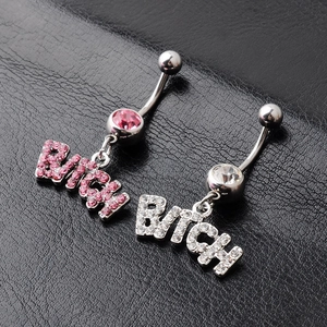 Bitch letter navel rings with pink and clear crystals on black leather background
