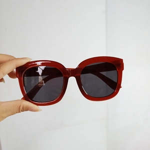 Close-up of retro square dark red sunglasses frames with tinted lenses for women