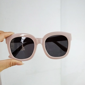 Close-up of pink oversized square sunglasses with dark lenses and thick frame details