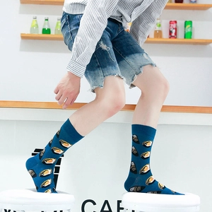 Deep blue crew socks with sushi print worn by a model in a casual cafe setting
