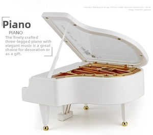 Detail of white piano music box showing inner golden movement and rose lid pattern