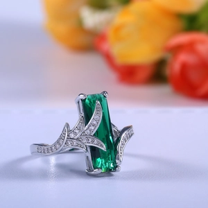 Macro shot of silver ring featuring a rectangular emerald cut gemstone and leaf design
