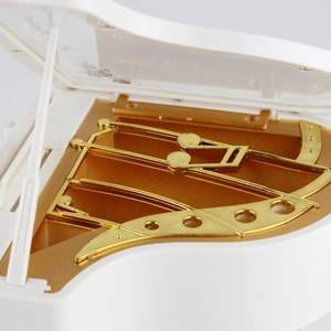 Creative piano music box with golden movement and elegant white outer casing