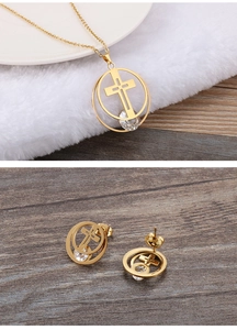 Macro detail of gold-plated necklace and earrings set with crystal cross and circle design