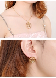 Detailed view of gold cross necklace and matching earrings set on a female model