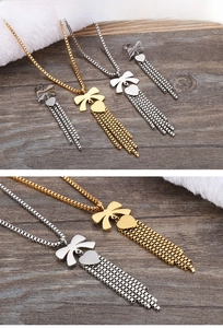 Dettaglio macro del set collana con fiocco e nappa a cuore in oro e argento