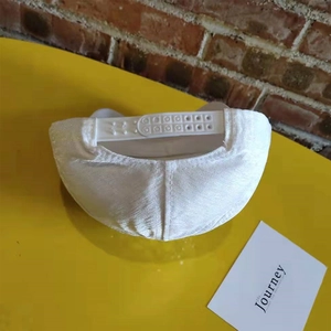 Detailed view of the adjustable white baseball cap strap with a plastic buckle design