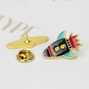 Cartoon rocket enamel pin with golden metal edges and secure butterfly clutch base