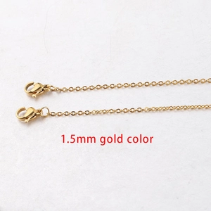 Detailed macro view of 1.5mm gold-colored stainless steel chain with lobster clasps