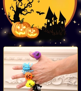 Detail of Halloween glowing rings featuring pumpkin, bat, and spider icons on fingers