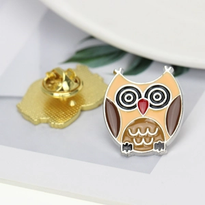 Macro view of cartoon owl enamel pin showing front details and butterfly clutch back