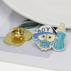 Detail of alloy owl brooch with blue cap and bottle, showing front design and back butterfly clutch