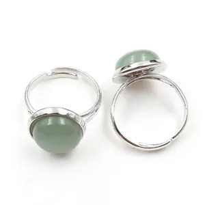Top view of two adjustable silver rings featuring round green stone beads on white background