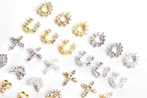 Detailed view of alloy nail art charms with pearls, rhinestones and heart cross shapes
