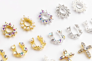 Detail of alloy nail charms with pearls and rhinestones in U-shape and cross designs