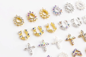 Detailed flat lay of gold and silver nail charms with pearls and rhinestones
