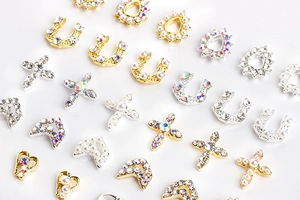 Detailed view of alloy nail art charms with pearls, heart shapes and crystal rhinestones