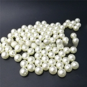 Macro shot of polished white faux pearl beads with pre-drilled holes for DIY jewelry