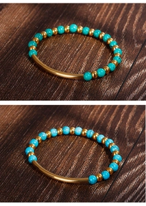 Macro detail of turquoise beads and golden metal tube on a beaded bracelet