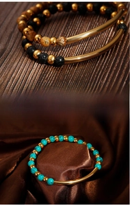 Detailed view of turquoise beads and black lava stone bracelets with golden metal accents