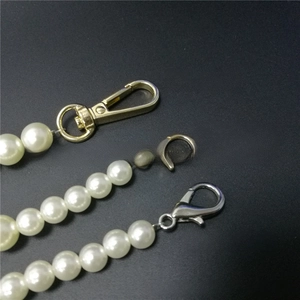 Detail view of pearl bag chains with gold and silver lobster clasps for purses