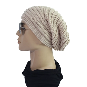 Detail view of beige chunky knit beanie featuring premium texture on a mannequin