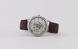 Detail of silver hollow mechanical watch with brown leather strap and Roman numerals