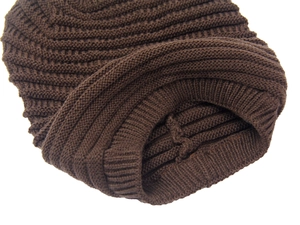 Close-up of dark brown knitted beanie showing thick ribbed texture and hem detail