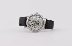 Macro shot of silver hollow-out watch dial with black Roman numerals and leather strap