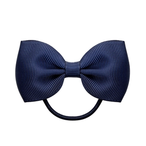 Close-up of dark blue grosgrain ribbon bow with elastic band on white background
