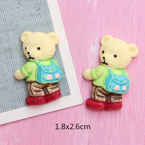 Detail of 1.8x2.6cm resin bear accessories with green shirt and blue backpack