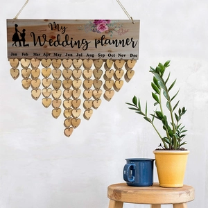 Detail of wooden My Wedding Planner wall hanging with decorative heart shape month tags