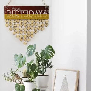 Detail of wooden family birthday calendar with heart-shaped tags and greenery background