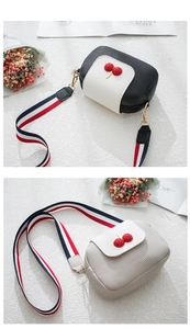 Detail of lychee pattern crossbody bag with 3D cherry accent and colorful strap