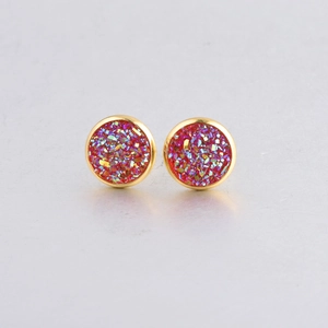 Macro shot of 10mm circular stud earrings with pink druzy resin crystals in gold settings