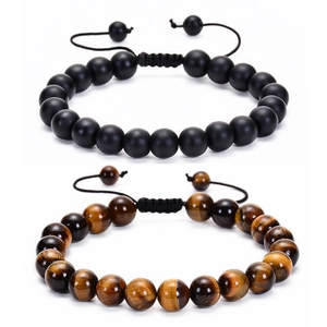 Close-up of matte black beads and tiger eye stones on adjustable braided cord bracelets