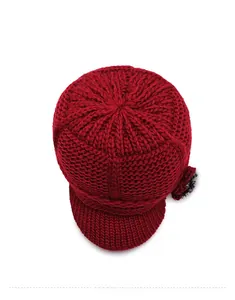 Detailed top view of a wine red knitted winter hat with floral accent and thick yarn