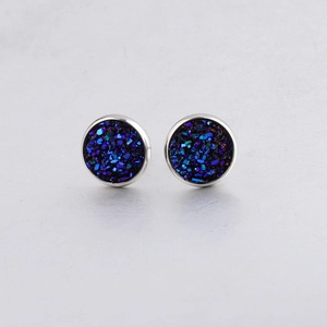 Close-up of 10mm silver druzy stud earrings with dark blue glittering crystal inlay